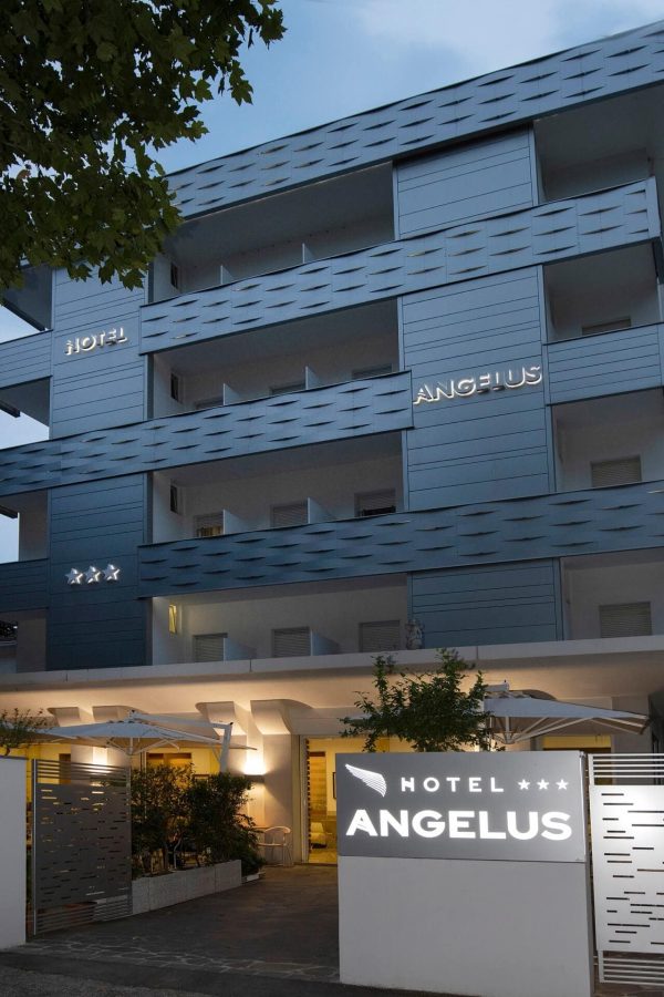 Exterior view of the modern Hotel Angelus building with illuminated signage and balconies.