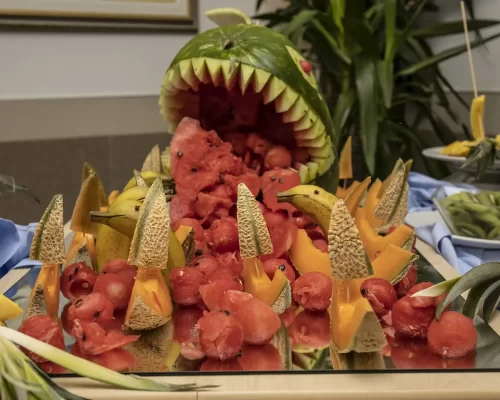 Composizione artistica di frutta con un'anguria intagliata a forma di faccia mostruosa.