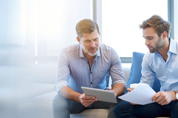 Mature,Businessman,Using,A,Digital,Tablet,To,Discuss,Information,With