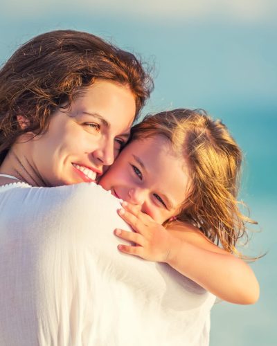 Portrait,Of,Happy,Mother,And,Little,Daughter,On,Sunny,Beach